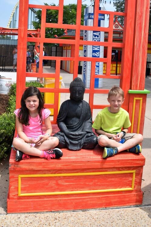 girl and boy sitting with Buddha statue enjoying The Power of WOW experience 