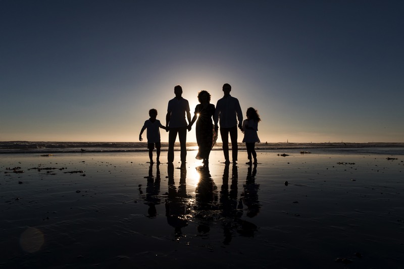 family holding hands on the beach at sunset enjoying a JAJF WOW experience 