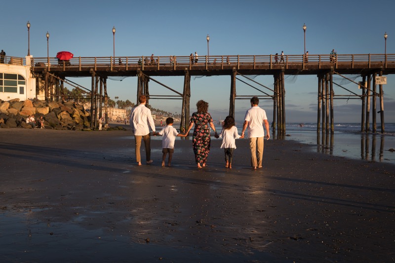 family walking on beach holding hands enjoying a JAJF WOW experience 