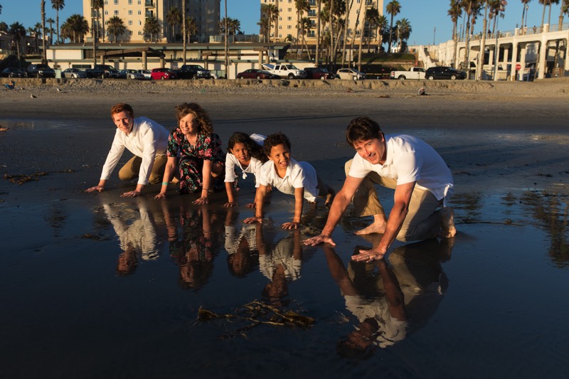 family in white shirts and khakis on the beach enjoying a JAJF WOW experience 