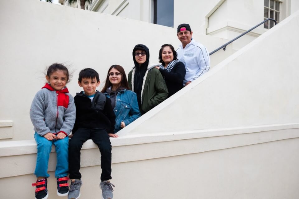 family posing on stairs enjoying The Power of WOW experience 
