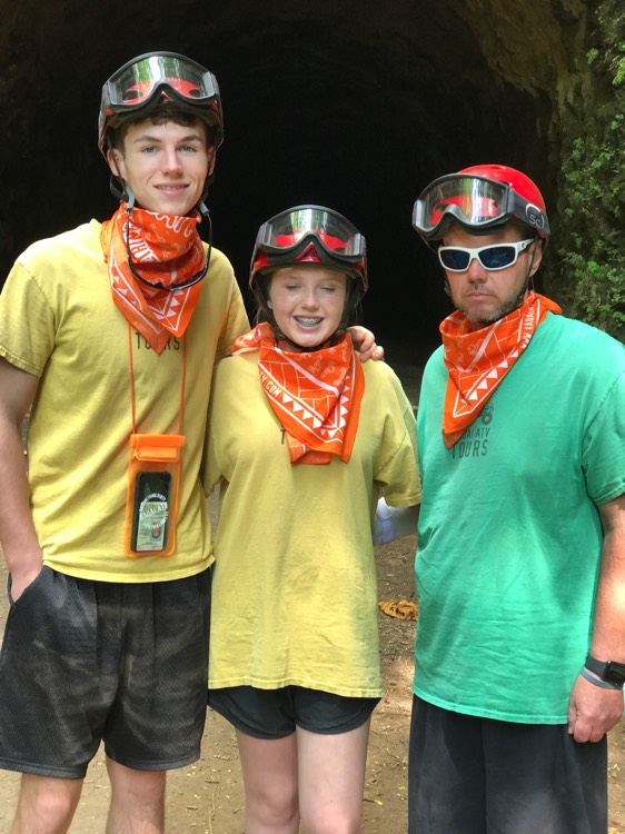 three family members with orange bandanas around necks during a JAJF trip treating the families not the cancer 