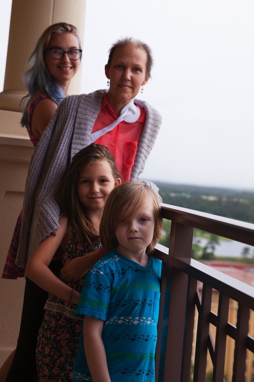 mom with two young daughters on hotel balcony during a JAJF trip treating the families not the cancer 