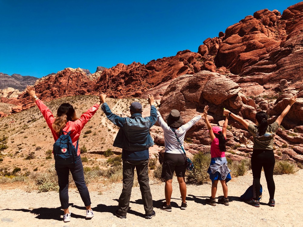 JAJF family holding hands in the air during a hike on a late stage cancer timeout 
