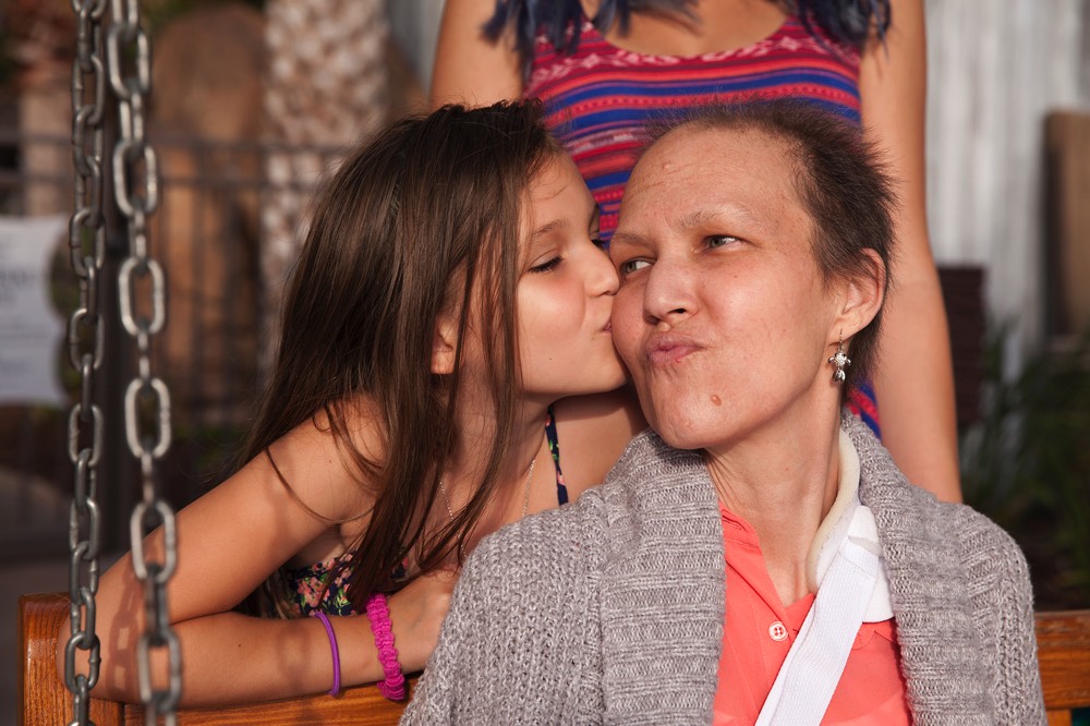 daughter kissing mom on the cheek during a JAJF trip treating the families not the cancer 