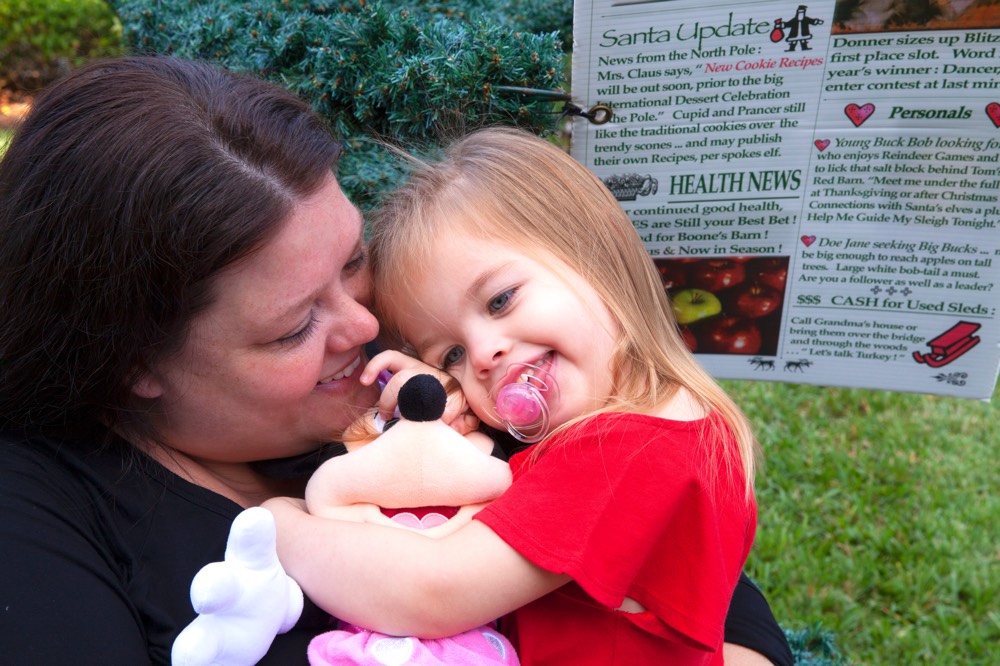 mom hugging daughter holding stuffed Minnie Mouse during a JAJF trip treating the families not the cancer 