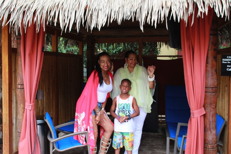 mom in pink bathing suit wrap with son in pool cabana enjoying a JAJF Wow Experience 