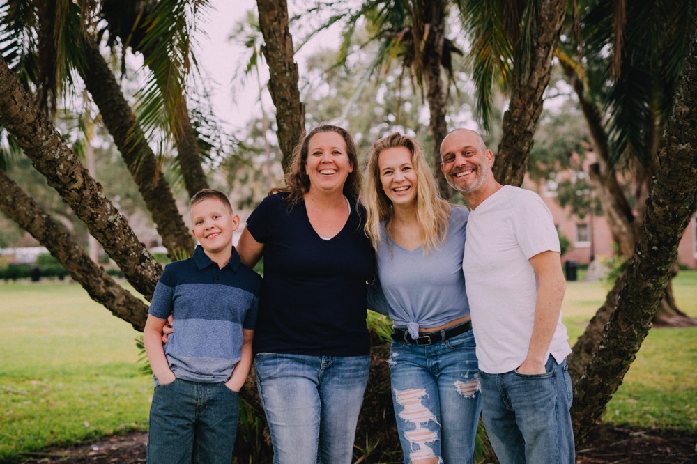 family in front of a palm tree on a JAJF WOW experience 