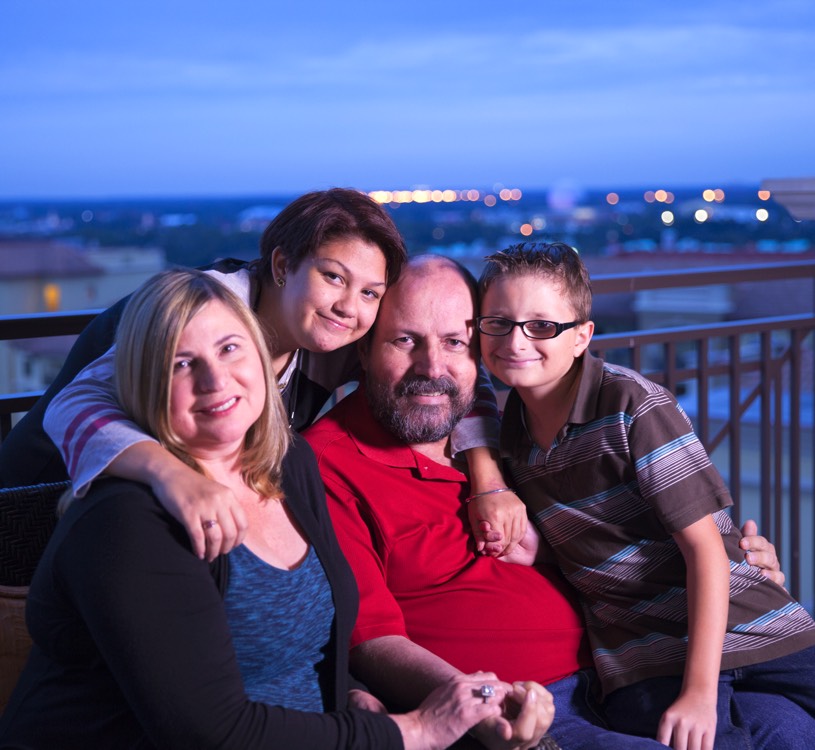 Mom and dad with daughter and son on hotel balcony during a JAJF trip treating the families not the cancer 