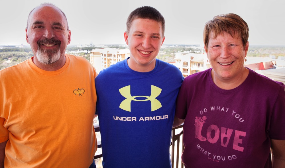 couple with teenage son on hotel balcony enjoying a JAJF WOW experience 