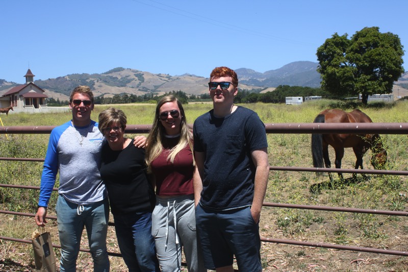 family beside horses in an outdoor pasture enjoying a JAJF Wow Experience 