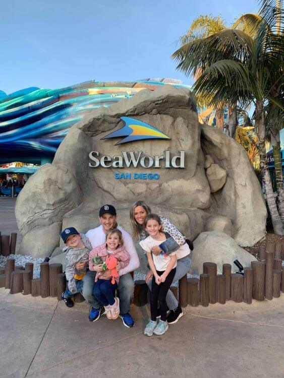 family at SeaWorld sign enjoying The Power of WOW experience 