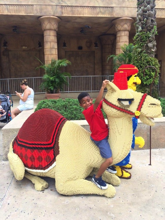 young boy on camel statue on a JAJF WOW experience 