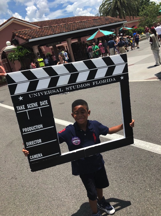young boy holding Universal Studios photo prop on a JAJF WOW experience 
