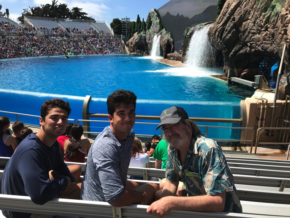 dad and sons in stadium at SeaWorld enjoying The Power of WOW experience 