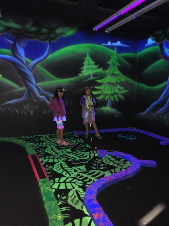 JAJF girls playing miniature golf in indoor course 