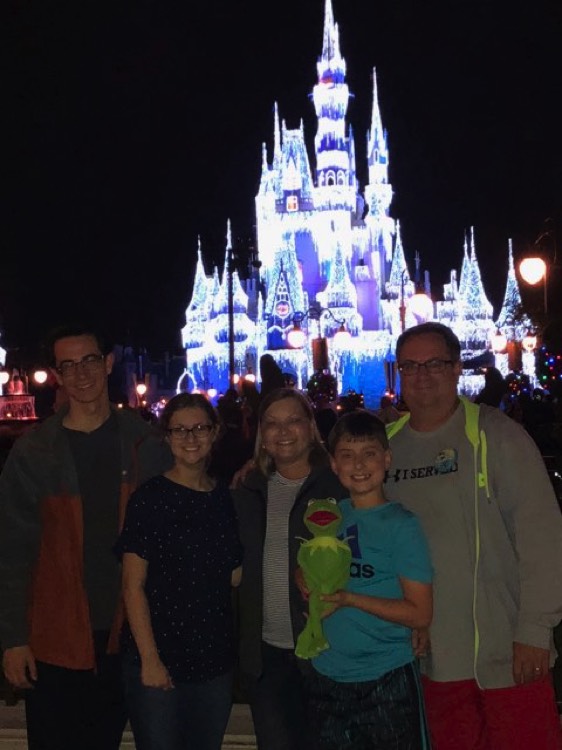 family in front of Cinderella's castle at night on a JAJF WOW experience 