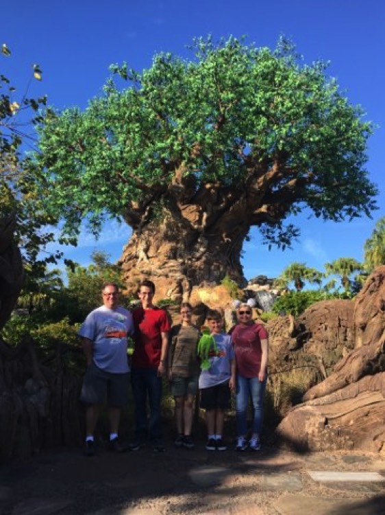 family in front of tree at Animal Kingdom on a JAJF WOW experience 