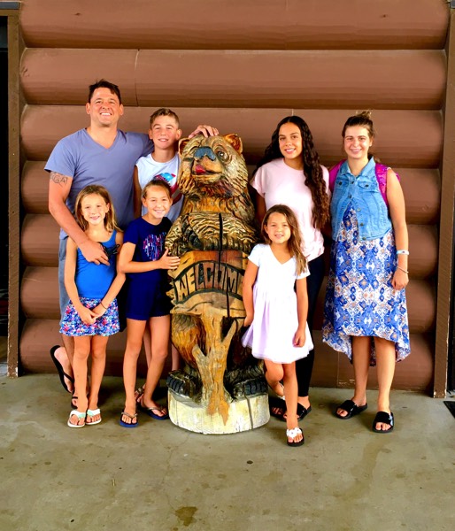 family with Great Wolf Lodge statue enjoying a JAJF WOW experience 