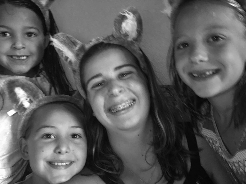 black and white photo of mom and daughters wearing animal ear headbands enjoying a JAJF WOW experience 
