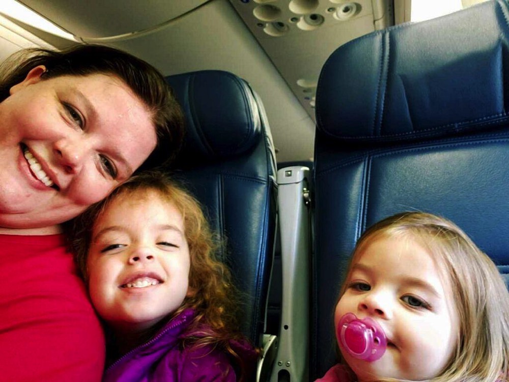 mom taking selfie with two young daughters on airplane during a JAJF trip treating the families not the cancer 