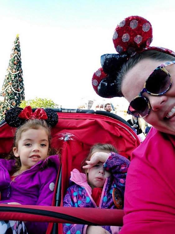 mom with Minnie ears taking a selfie with two young daughters wearing Minnie ears during a JAJF trip treating the families not the cancer 