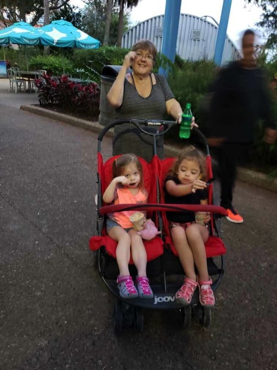 mom walking two young daughters in double stroller during a JAJF trip treating the families not the cancer 