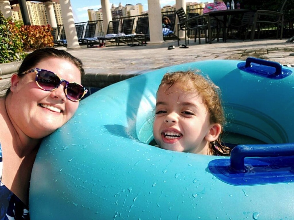 mom next to daughter in pool float during a JAJF trip treating the families not the cancer 