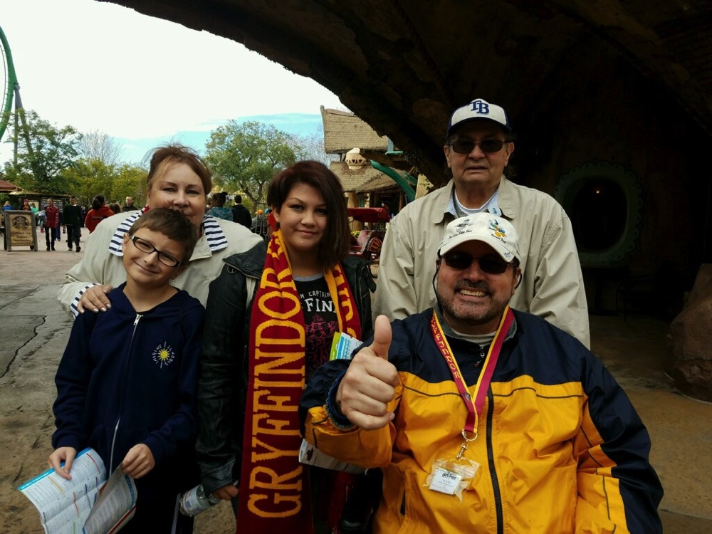 Family of five with woman wearing Gryffindor scarf on JAJF trip treating the families not the cancer 