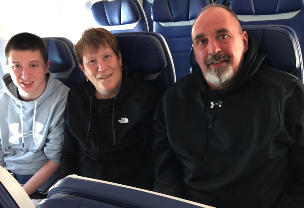 mom and dad with teenage son on airplane enjoying a JAJF WOW experience 