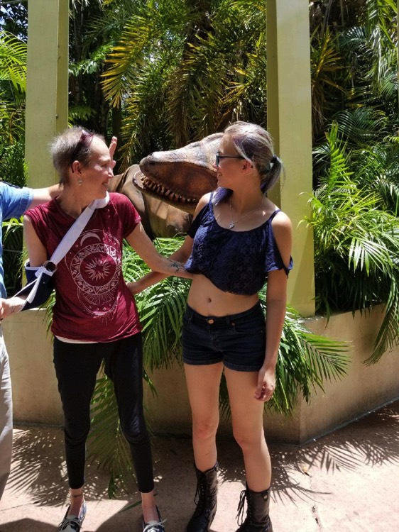 mom and daughter next to dinosaur statue at Universal Studios during a JAJF trip treating the families not the cancer 