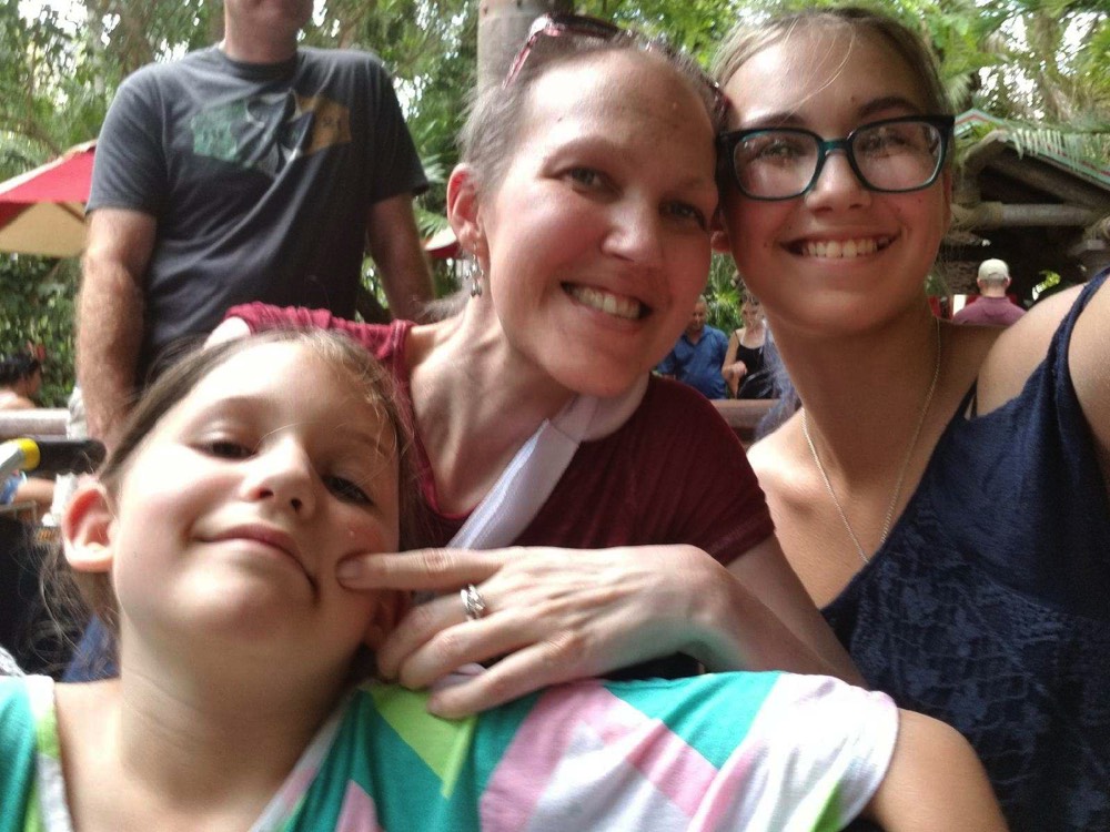 daughters hugging mom at Universal Studios during a JAJF trip treating the families not the cancer 