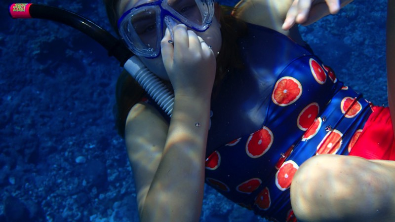 young girl with goggles holding her nose underwater enjoying a JAJF WOW experience 