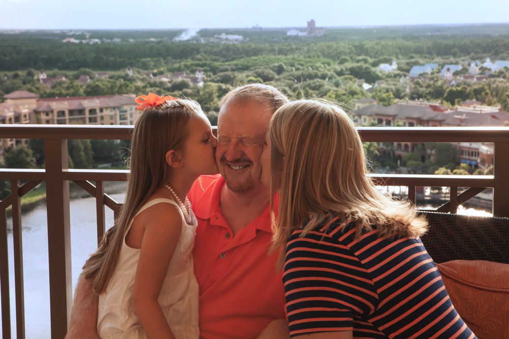 mom and daughter kissing dads cheek on a JAJF WOW experience 
