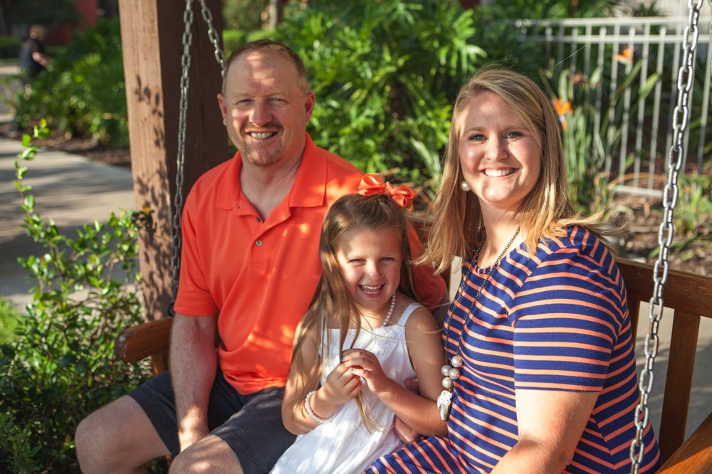 mom and dad posing with daughter on a bench on a JAJF WOW experience 
