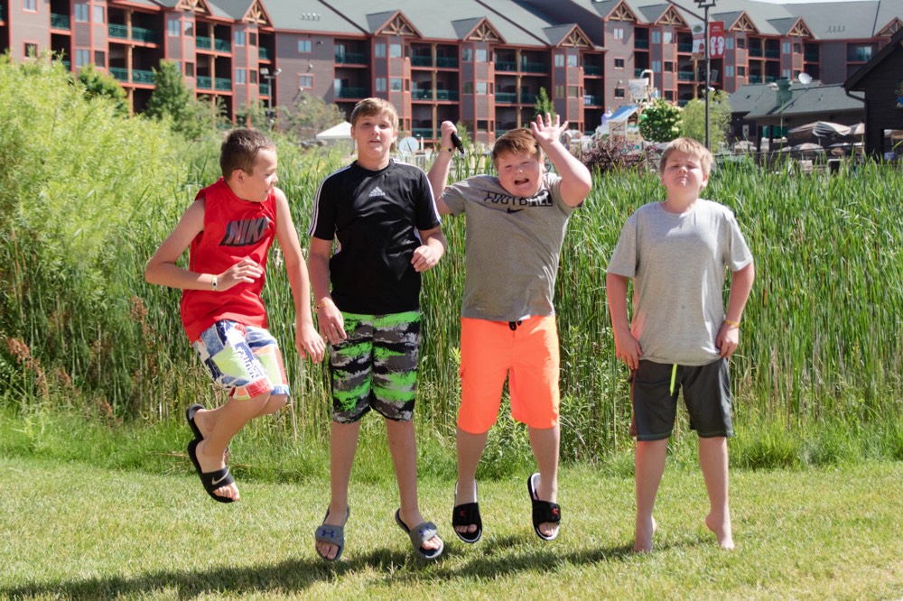 boys in bathing suits jumping in the air enjoying a JAJF WOW experience 