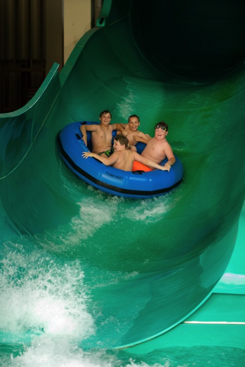 family in large inflatable going down water slide enjoying a JAJF WOW experience 